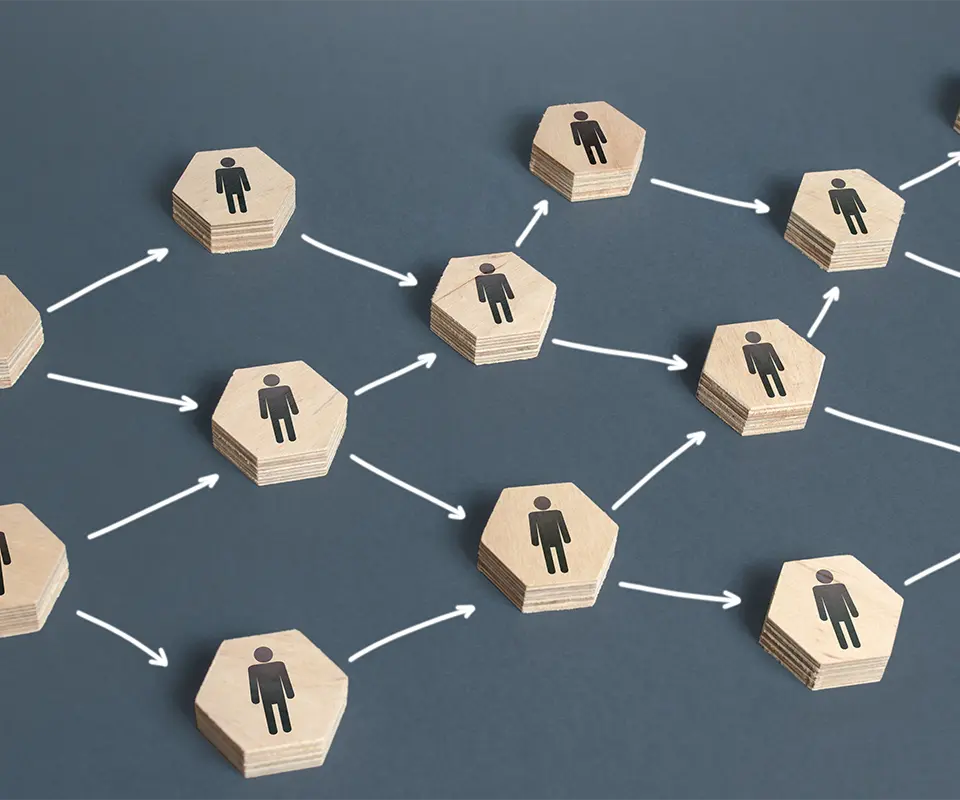 A branched-chain of sequential transmission of information made of wooden blocks with people drawn on them.